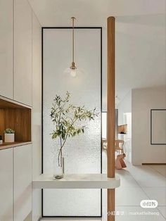 a vase filled with flowers sitting on top of a white counter next to a wooden shelf