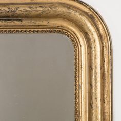 an ornate gold framed mirror against a white wall