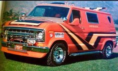 an orange and black van parked in the grass