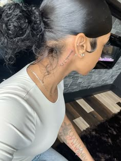 a woman with black hair and tattoos on her neck