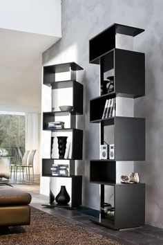 a living room filled with lots of black and white bookshelves next to a couch