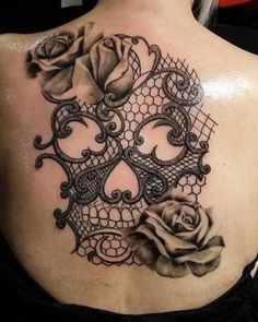 the back of a woman's shoulder with an intricate lace and roses on it