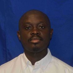 a man in a white shirt and tie posing for a photo against a blue background