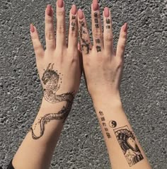 two hands with tattoos on them are holding each other's palms and their fingers