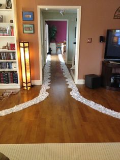 the room is decorated with white streamers and bookshelves, along with a television