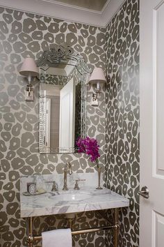 a white sink sitting under a bathroom mirror next to a wall mounted faucet