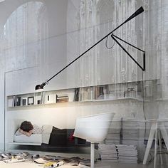 an image of a person sitting on a couch in front of a wall with books