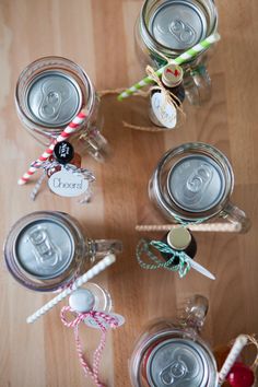 mason jars filled with candy canes on top of a wooden table next to other items