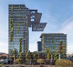 two tall buildings with plants growing on them