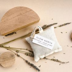 a small pillow sitting on top of a table next to some dried flowers and a wooden slice