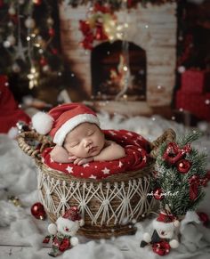 a newborn baby is sleeping in a basket with santa's hat on and decorations around him