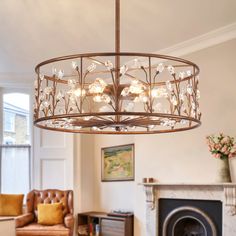 a chandelier hanging from the ceiling in a living room next to a fire place