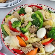 a bowl filled with vegetables and meat on top of a table