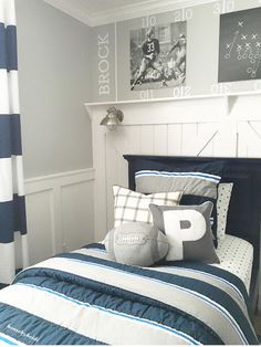 a bed room with a neatly made bed and pictures on the wall above it's headboard