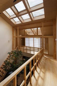 an empty room with wooden railings and skylights on the ceiling, next to a tree