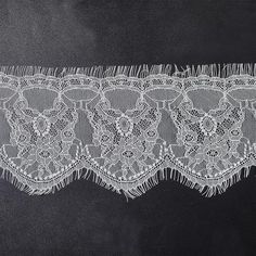 a white lace with fringes on a black background