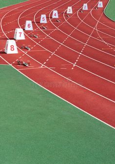 an aerial view of a track and field with numbers on the starting blocks in front of it