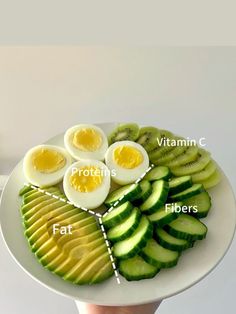 a white plate topped with sliced up vegetables and hard boiled eggs on top of each other