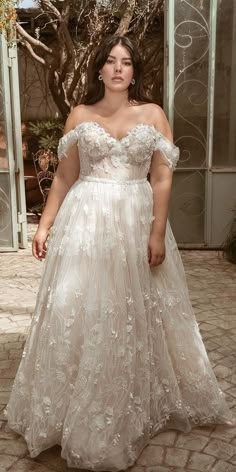 a woman in a wedding dress posing for the camera