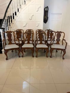 a set of six chairs sitting in front of a stair case