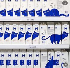 milk cartons with blue cats on them are for sale in a grocery store,