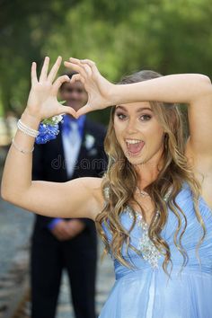 a woman in a blue dress making the v sign with her hands