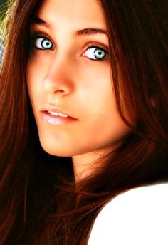 a woman with blue eyes and long brown hair