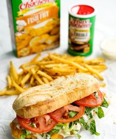 a sandwich and french fries are sitting on the table next to some condiments