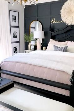 a black and white bedroom with chandelier above the bed