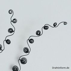 a string of black beads on a white background with the word dream written below it