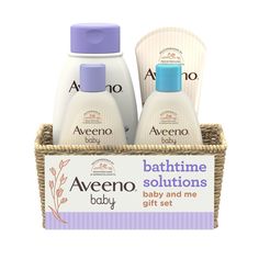 two bottles of baby lotion in a basket next to a sign that says,'aveenoo bathtime solutionss for babies and me gift set '