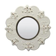 a white mirror with an ornate design on it