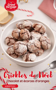 a white bowl filled with chocolate crinkles on top of a table next to candy canes