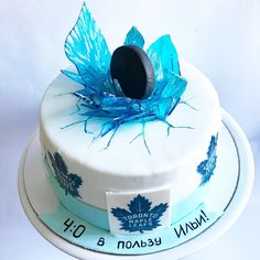 a white cake with blue frosting and leaves on it