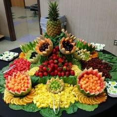 a table topped with lots of fruits and vegetables on top of a black table cloth