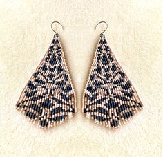 two pairs of beaded earrings on top of a white carpeted floor next to each other