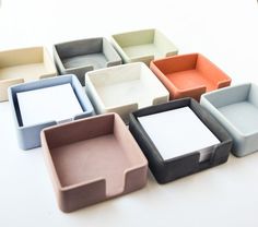 there are many different colored trays on the table, each with one empty square