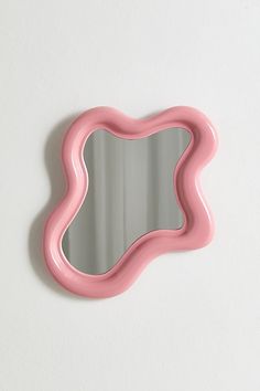 a pink mirror mounted to the side of a wall