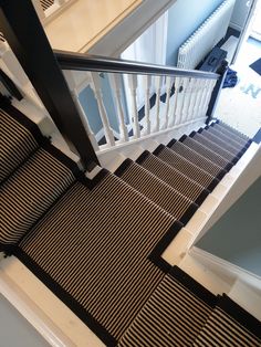 the stairs are lined with black and white striped carpet