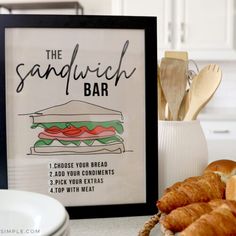 the sandwich bar sign is next to croissants and bread