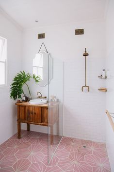 a bathroom with pink floor tiles and white walls