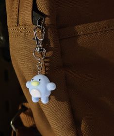 a keychain with a small plastic animal on it's side hanging from a pocket