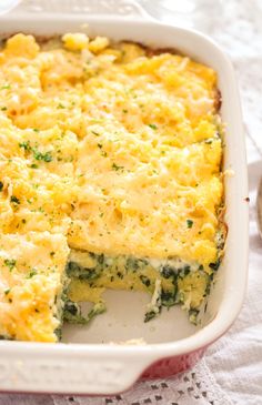 a casserole with cheese and spinach in a white dish on a table