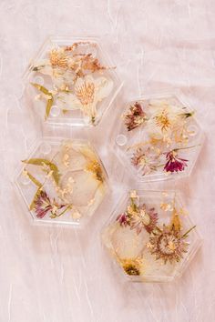 four plastic containers with dried flowers in them