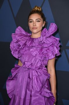 a woman in a purple dress posing for the camera