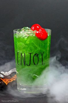 a green drink with a red cherry on top and the words enjoy written on it