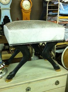 a white bench sitting on top of a wooden table next to clocks and other furniture