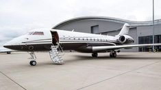 an airplane is parked in front of a building