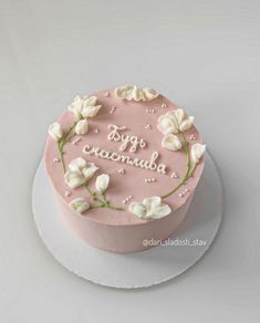 a pink cake with white flowers on it