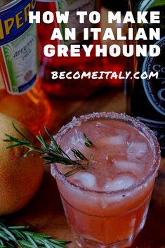 a close up of a drink in a glass with ice and rosemary on the rim